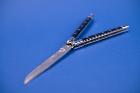 still life- black butterfly knife on blue ground