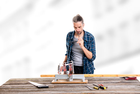 worker in blue plaid  shirt sawing woodの写真素材