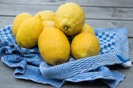 yellow lemons with blue towel on wooden groundの写真素材