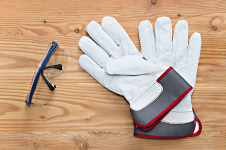 goggles and work gloves on wooden groundの写真素材