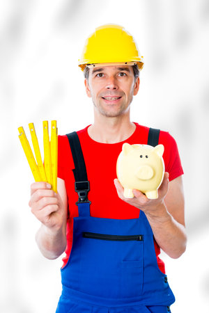 worker with yardstick and piggy bankの写真素材