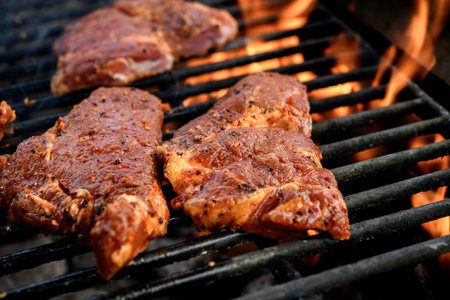 grilled pork with flames on charcoal barbecueの写真素材