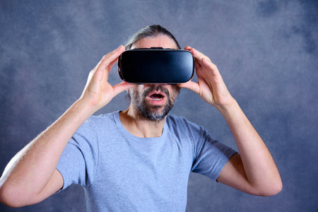 young man with virtual reality glasses looking surprisedの写真素材