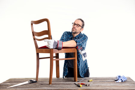 worker in blue plaid  shirt repair old chairの写真素材