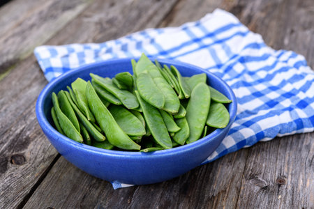 blue bowl with green peapods and towelの写真素材