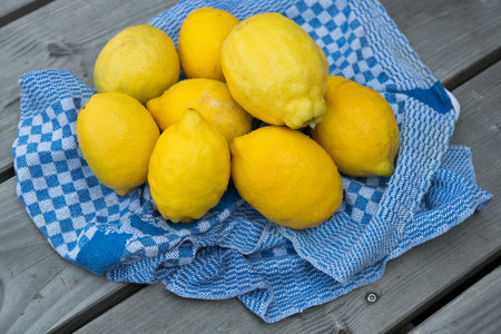 yellow lemons with blue towel on wooden groundの写真素材