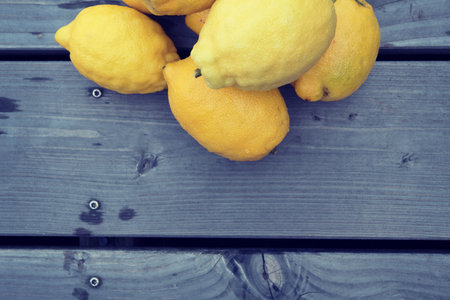 pile of yellow lemons on wooden groundの写真素材