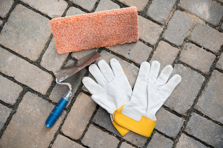 trowel, sponge board and work gloves on stone groundの写真素材