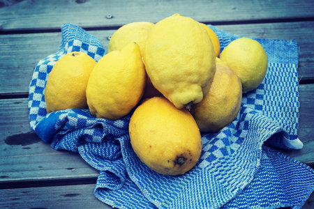 yellow lemons with blue towel on wooden groundの写真素材