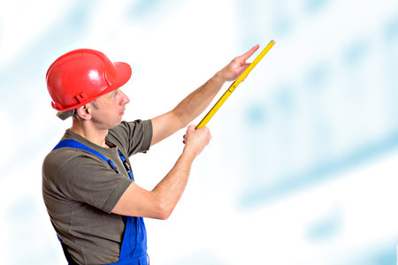 worker with yardstick in front of bright backgroundの写真素材