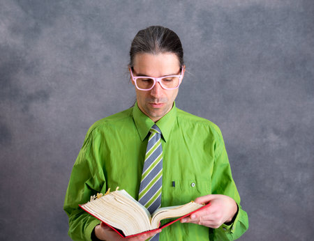 young lawyer in green shirt and  necktie  with statute book and pink glassesの写真素材
