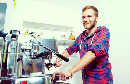young bearded man in checkered shirt with his espresso machineの写真素材