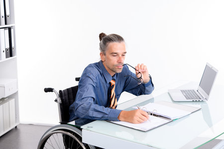 disabled business man in wheelchair working  in the officeの写真素材