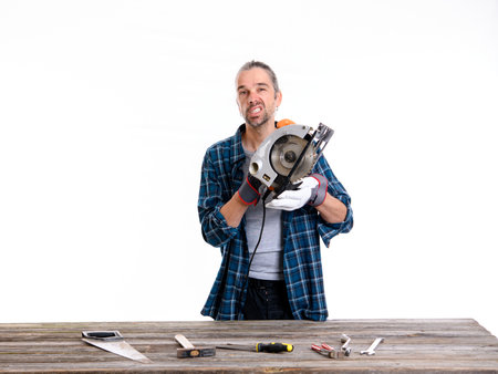 funny worker in blue plaid  shirt working with wood