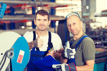two worker in factory on the machine with thumb upの写真素材