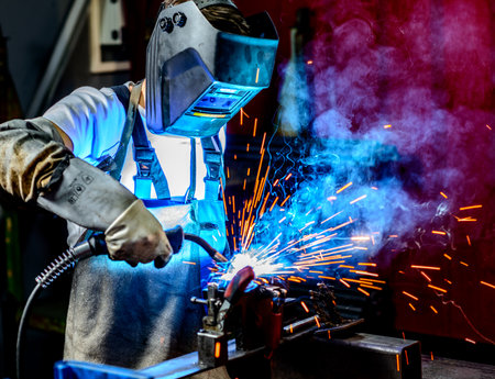 man welding metal in the factoryの写真素材