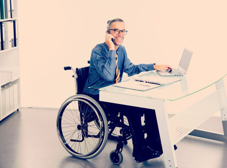 disabled business man in wheelchair working  in the officeの写真素材