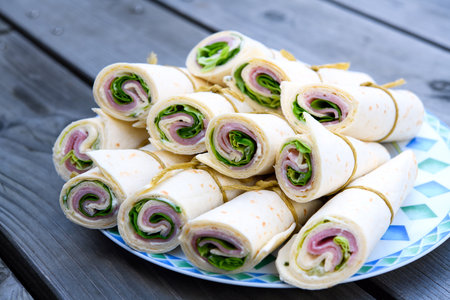 wraps with ham and salad on plateの写真素材