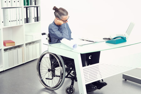 disabled business man in wheelchair is sorrowful  in the officeの写真素材