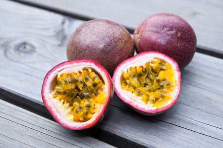 passion fruit halved and closed on wooden groundの写真素材