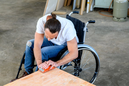 disabled worker in wheelchair in a carpenter's workshopの写真素材
