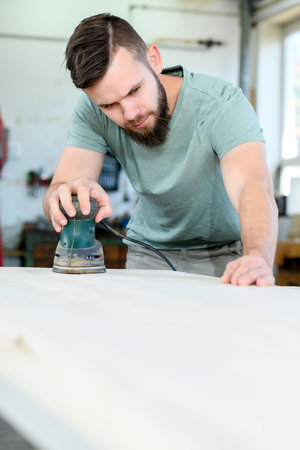 young worker with workpiece in a carpenter's workshopの写真素材