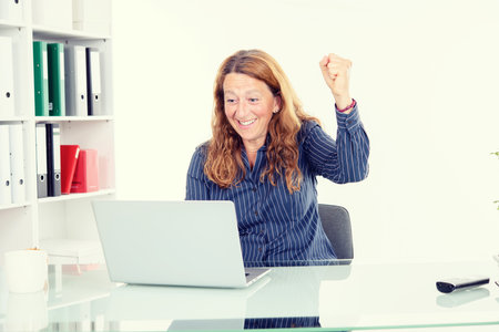 young amazed business woman at his deskの写真素材
