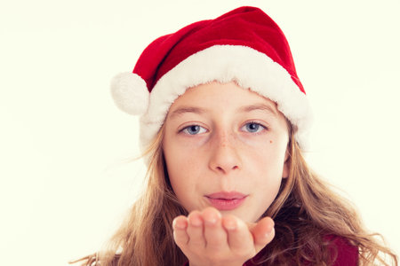 blond girl with Santa- Claus cap blowing over the handの写真素材