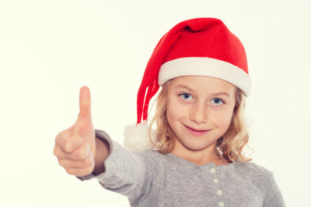 nice blond girl with Santa- cap and thumb upの写真素材