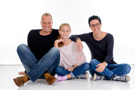 happy family sitting in front of white backgroundの写真素材