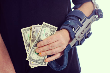 man with broken arm and dollar notesの写真素材