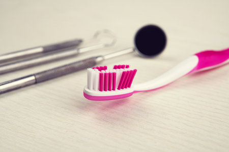 three different dental instruments and toothbrush on bright groundの写真素材