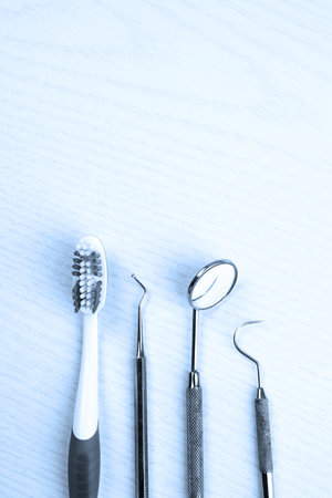 three different dental instruments and toothbrush on bright groundの写真素材