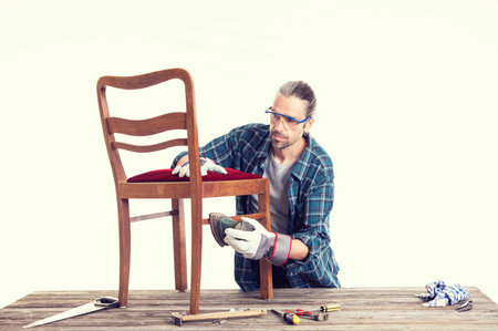 worker in blue plaid  shirt repair old chairの写真素材