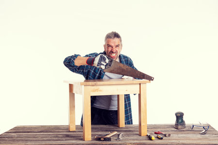 funny worker in blue plaid  shirt working with woodの写真素材