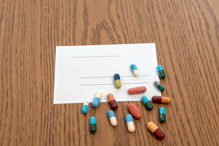 prescription with colorful pills on wooden groundの写真素材