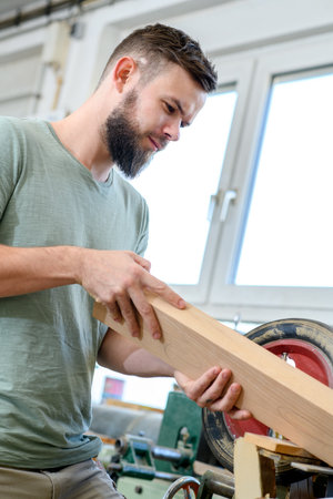 young worker with workpiece in a carpenter's workshopの写真素材