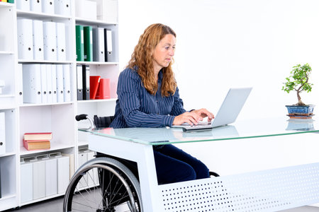 disabled businesswoman in wheelchair working  in the officeの写真素材