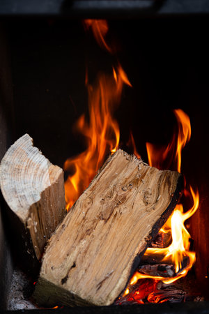 birning wood with flames and embers in fireplaceの写真素材