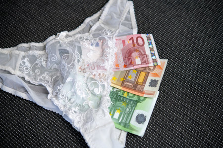 white woman panties with money on dark groundの写真素材