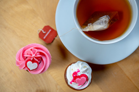 pink and white muffins  with cup of teaの写真素材