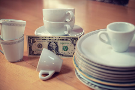 older dishes set with money on the floor in living roomの写真素材