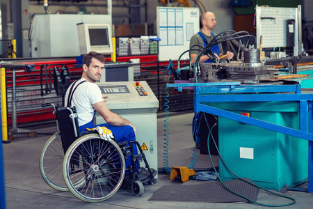 disabled worker in wheelchair in factory on the machineの写真素材