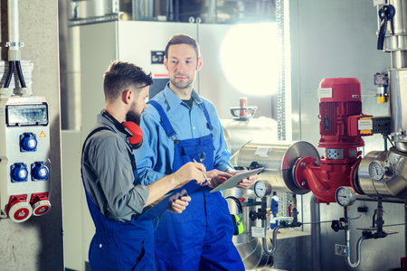 two worker in blue work clothes in industrial plantの写真素材