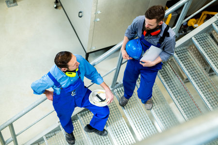 two worker in blue work clothes in industrial plantの写真素材