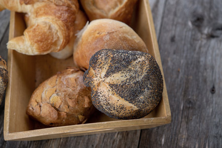 different fresh rolls and croissants in wooden basketの写真素材
