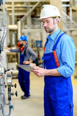 worker with helmet and electric tool  in industrial plantの写真素材