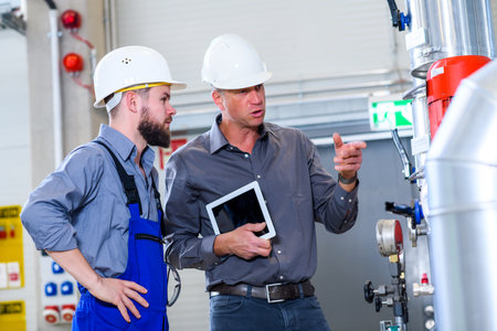 boss with worker in the background in his factoryの写真素材