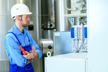 worker with helmet and electric tool  in industrial plantの写真素材