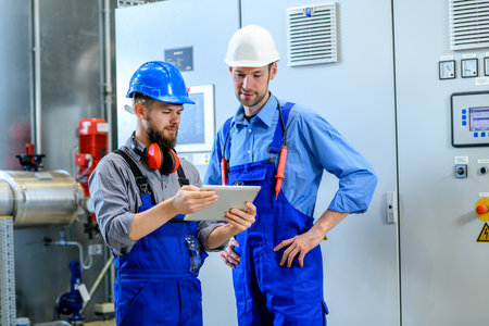 two worker in blue work clothes in industrial plant